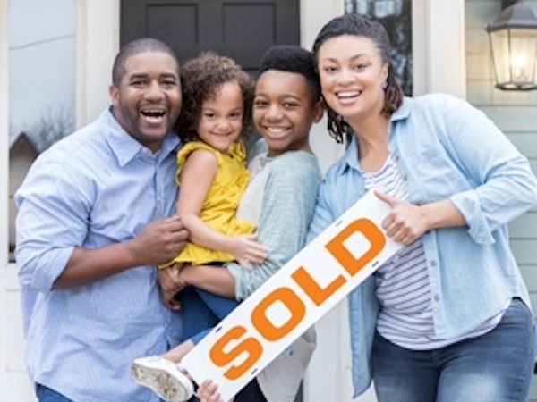 family holding the sold sign